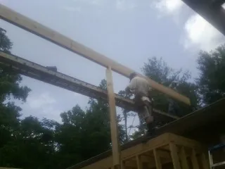 Carpenter setting a ridge beam over a new addition frame — Ice Dam Removal by Roofing Brothers in Meigs