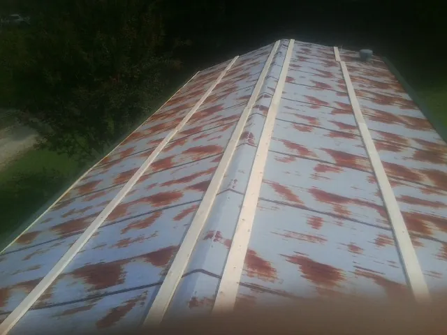 Rusted metal roof panels with new wood purlins before replacement — Storm Damage Roof Repair in Meigs by Roofing Brothers
