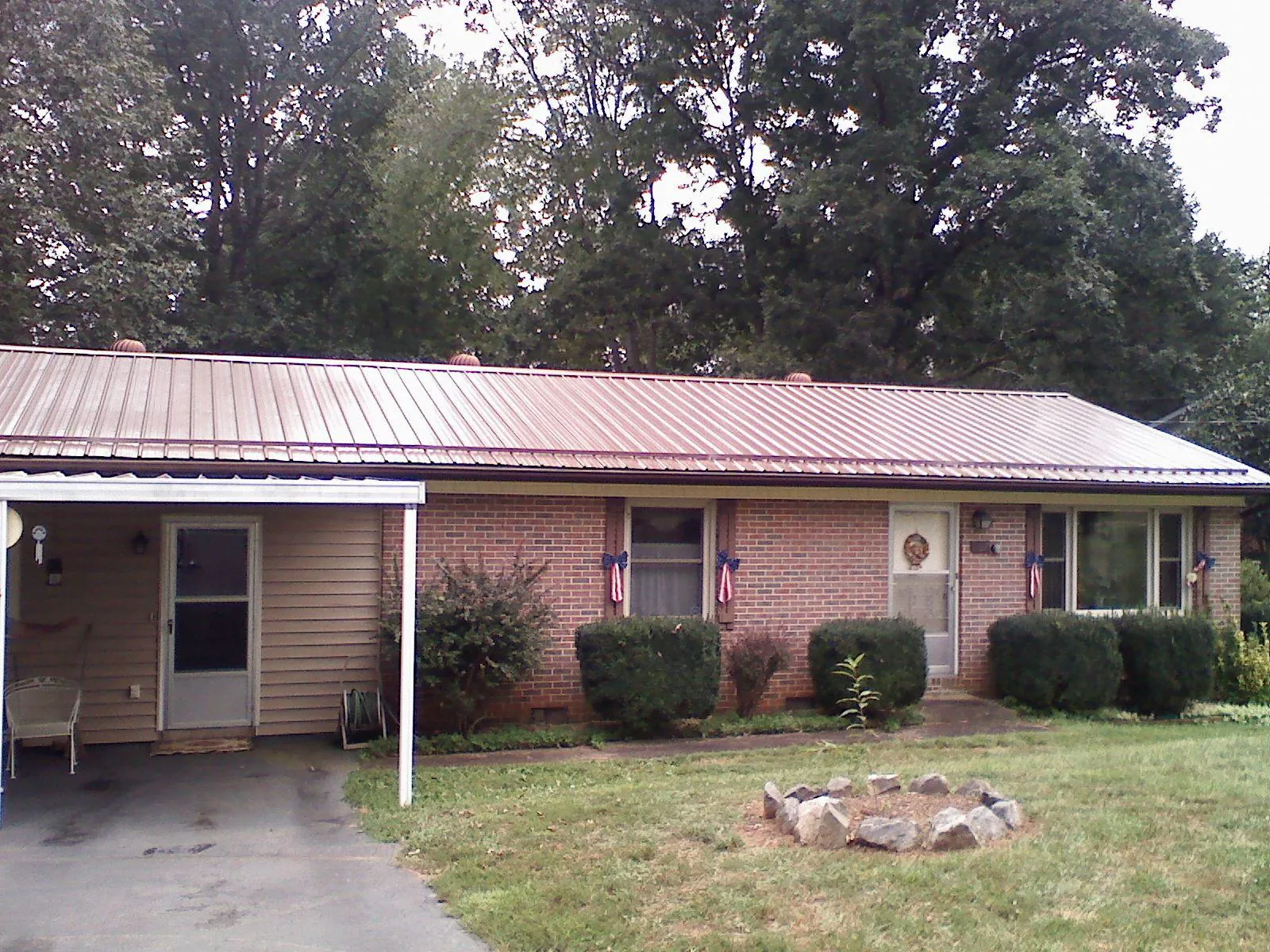 Bronze metal roof and carport on a brick ranch home — Roof Repair work by our crew in Meigs